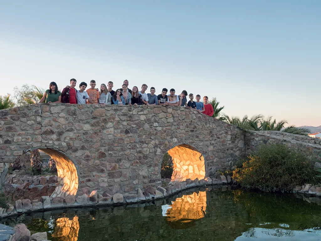 Die Gruppe steht auf einer alten Steinbrücke über dem Wasser.